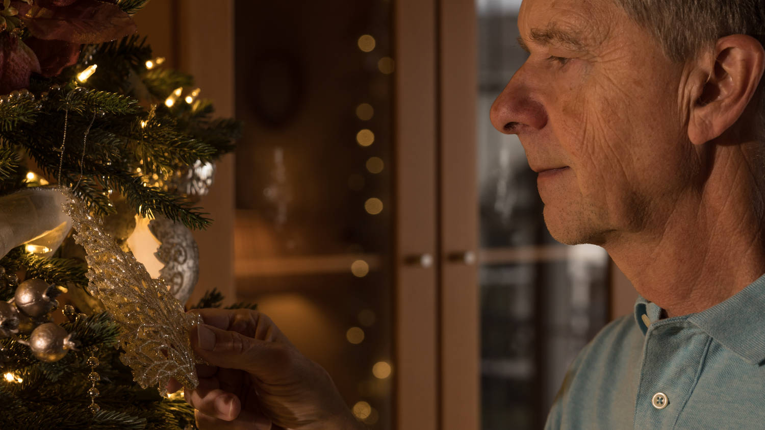 Senior adult man holding a christmas ornament