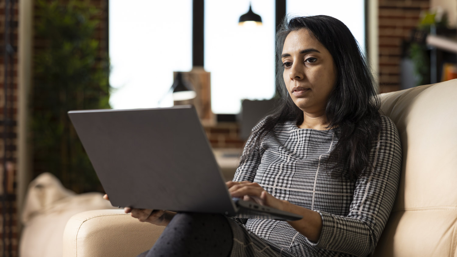 Indian woman editing blog post on laptop